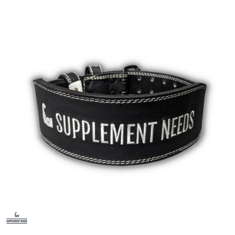 A black weightlifting belt with the brand name 'Supplement Needs' written in white. The belt features a metal buckle and is displayed in an arch shape.