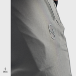 Close-up of a SN Clo. grey cargos with a zipper on the pocket and logo on a light grey background