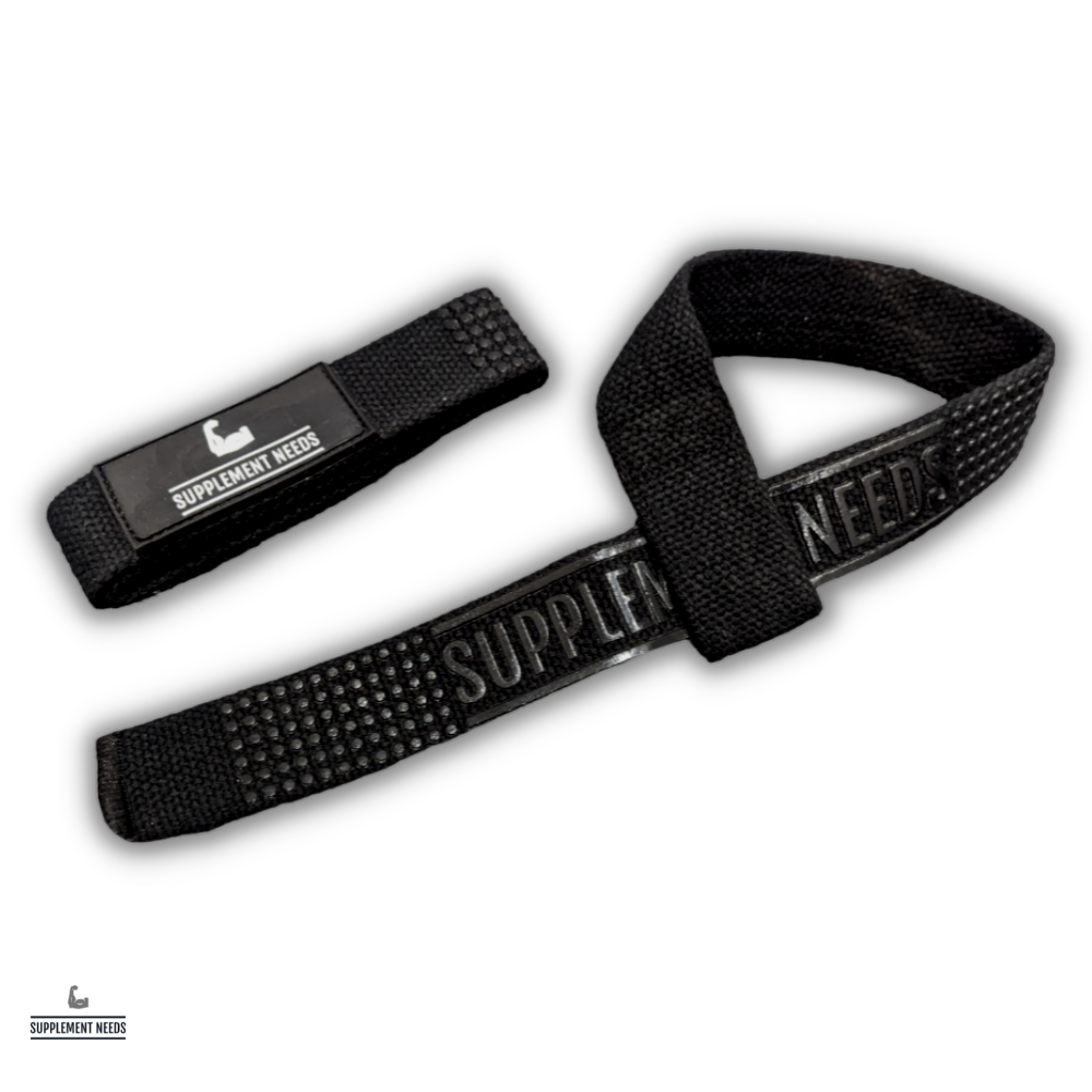 A pair of black lifting straps with the text 'Supplement Needs' printed across the grip area. The image shows the straps laid out with a focus on the texture and branding.